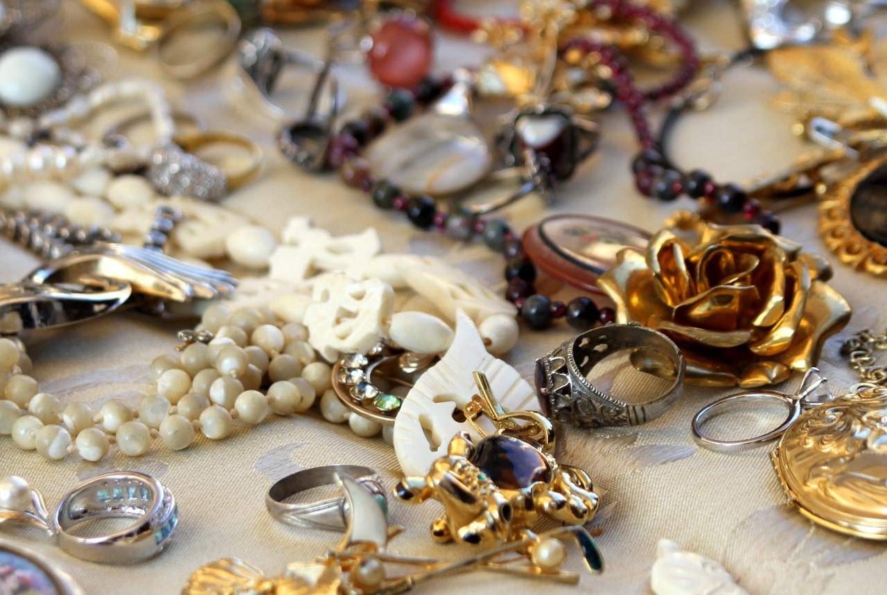 Various pieces of vintage jewelry lying on a surface covered in linen