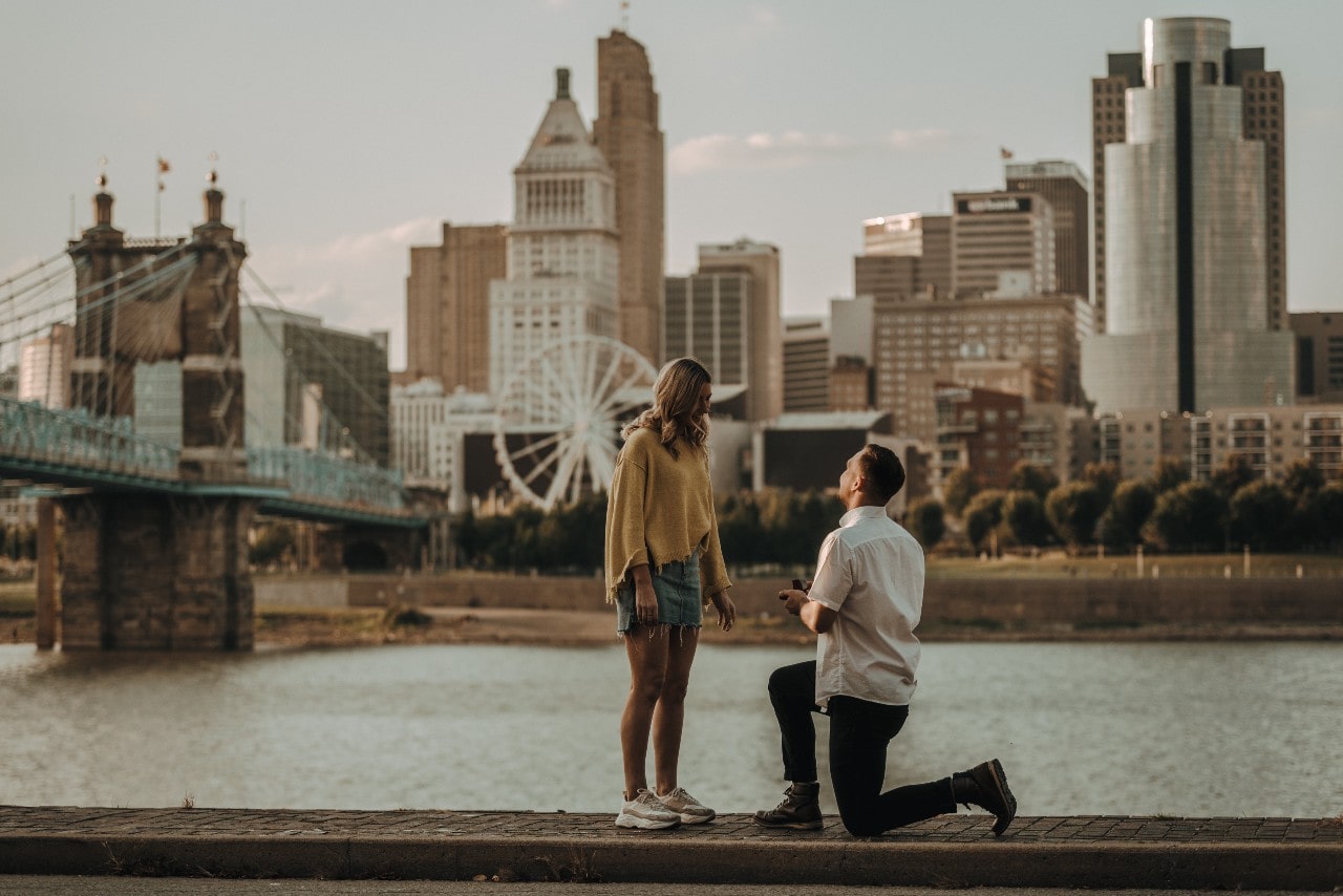 A man gets down on one knee and proposes to his girlfriend on a date